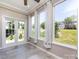 This sun room boasts natural light, neutral colors and tile flooring that looks out to a well manicured lawn at 621 Pine Links Dr, Tega Cay, SC 29708