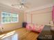 Bright bedroom features hardwood floors, large window, and a playful pink canopy bed at 6311 Red Maple Dr, Charlotte, NC 28277