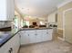 Open kitchen featuring white cabinets, granite countertops and seamlessly flowing to the living room at 6311 Red Maple Dr, Charlotte, NC 28277
