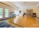 Spacious living room with hardwood floors, a blue cabinet, games, and ample natural light at 6311 Red Maple Dr, Charlotte, NC 28277