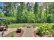 Picturesque backyard has lush landscaping, a fire pit, and mature trees at 6326 Jepson Ct, Charlotte, NC 28214