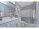 Bright, neutral bathroom with large mirror, white vanity, and shower-tub combo at 6326 Jepson Ct, Charlotte, NC 28214