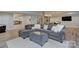 Basement living room featuring a cozy sectional sofa and adjacent kitchenette and staircase at 6326 Jepson Ct, Charlotte, NC 28214