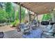 Covered patio boasts comfortable seating, an outdoor grill, and wooded views at 6326 Jepson Ct, Charlotte, NC 28214