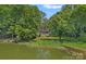 Aerial view of a beautiful home situated on a lush, treed lot with lake frontage at 640 Lochaven Rd, Weddington, NC 28173