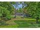 Beautiful backyard with lush greenery, mature trees, and a home in the background at 640 Lochaven Rd, Weddington, NC 28173