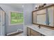 Well-lit bathroom featuring a large mirror, vanity, and shower at 640 Lochaven Rd, Weddington, NC 28173