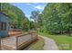 View from the backyard deck overlooks the property and a pond in the distance, with trees and greenery all around at 640 Lochaven Rd, Weddington, NC 28173