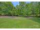 Circular driveway surrounded by a lush, green lawn and mature trees creates a welcoming approach to the property at 640 Lochaven Rd, Weddington, NC 28173