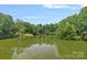 Scenic view of a tranquil lake surrounded by lush greenery and clear blue skies at 640 Lochaven Rd, Weddington, NC 28173