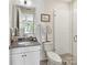 Bright bathroom with a glass enclosed shower, neutral tile, and vanity storage at 6531 Hazelton Dr, Charlotte, NC 28210