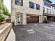 Charming two-story townhome with a brick driveway and a wooden garage door at 6531 Hazelton Dr, Charlotte, NC 28210