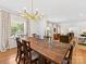 Open-concept dining room with hardwood floors, modern chandelier, and adjacent living area at 6745 Lancer Dr, Charlotte, NC 28226