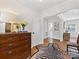 Elegant foyer featuring hardwood floors, stylish rug, decorative dresser, and open hallway at 6745 Lancer Dr, Charlotte, NC 28226