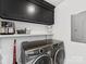 Functional laundry area with shelving, storage cabinets, and modern washer and dryer units at 6745 Lancer Dr, Charlotte, NC 28226