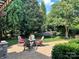 Backyard patio with outdoor seating, a swing, mature trees, and beautiful landscaping at 7076 Brookstone Ln, Fort Mill, SC 29707