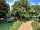 Scenic backyard featuring mature trees, lush green lawn, and a charming swing set at 7076 Brookstone Ln, Fort Mill, SC 29707