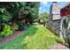 Spacious backyard with lush greenery, mature trees, manicured lawn and swing at 7076 Brookstone Ln, Fort Mill, SC 29707