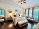 This main bedroom features a ceiling fan, three windows, a beige couch, and a plush bench at 7076 Brookstone Ln, Fort Mill, SC 29707