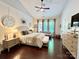 This main bedroom features a ceiling fan, three windows, a beige couch, and neutral decor at 7076 Brookstone Ln, Fort Mill, SC 29707