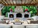 Outdoor fireplace beneath a pergola with stacked stone and comfortable wicker seating at 7076 Brookstone Ln, Fort Mill, SC 29707