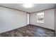 Well-lit bedroom features wood-look flooring, a window, and an open doorway at 716 Sharon Ln, Iron Station, NC 28080