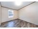 A cozy bedroom with wood-look flooring and a window, offering a serene and inviting space at 716 Sharon Ln, Iron Station, NC 28080