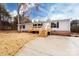 The home features a concrete driveway, wooden porch and is set amongst trees and greenery at 716 Sharon Ln, Iron Station, NC 28080