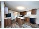 Open eat-in kitchen features an island, range, sink, and lots of counter space with wood cabinets at 716 Sharon Ln, Iron Station, NC 28080