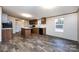 Modern kitchen featuring wood cabinetry, an island, and plank flooring at 716 Sharon Ln, Iron Station, NC 28080