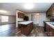 Stylish kitchen with island, wood cabinetry, modern appliances, and plank flooring at 716 Sharon Ln, Iron Station, NC 28080