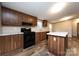 Open eat-in kitchen features an island, a range, sink, and lots of counter space with wood cabinets at 716 Sharon Ln, Iron Station, NC 28080