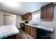 An eat-in kitchen features a sink, range, and breakfast bar with stone countertops and wood cabinets at 716 Sharon Ln, Iron Station, NC 28080