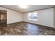 A large living area features wood floors, two windows, and an open doorway at 716 Sharon Ln, Iron Station, NC 28080