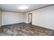 A simple living area features wood floors, a doorway, and ample light from an overhead light at 716 Sharon Ln, Iron Station, NC 28080