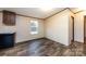 An open living area features wood floors and ample sunlight from a window by the kitchen at 716 Sharon Ln, Iron Station, NC 28080