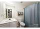 Bright bathroom with a single sink vanity, tile floors, and a shower at 7518 Silver Arrow Dr, Charlotte, NC 28273