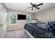 Bedroom featuring a ceiling fan, two windows, and carpet floors at 7518 Silver Arrow Dr, Charlotte, NC 28273
