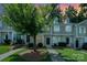 Charming townhome exterior with manicured lawn, mature tree, and sidewalks at 7518 Silver Arrow Dr, Charlotte, NC 28273