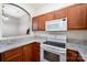 Bright kitchen featuring wood cabinets, granite countertops, and modern white appliances at 7518 Silver Arrow Dr, Charlotte, NC 28273