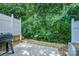 Back patio area provides a secluded outdoor space surrounded by lush greenery at 7518 Silver Arrow Dr, Charlotte, NC 28273