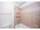 Cozy bathroom featuring tile surround, a tub and shower, and neutral color scheme at 7554 Bluestar Ln, Charlotte, NC 28226