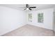 Bright bedroom featuring neutral carpeting, a ceiling fan, and two windows with blinds at 7554 Bluestar Ln, Charlotte, NC 28226
