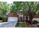 Charming two-story brick home featuring an attached two car garage and mature landscaping at 7554 Bluestar Ln, Charlotte, NC 28226