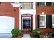 Inviting entryway with a dark front door, white trim, and lush green bushes, enhanced by black shutters at 7554 Bluestar Ln, Charlotte, NC 28226