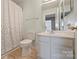 Bathroom featuring a white sink and toilet with a shower and a curtain at 8417 Hirsch Dr, Charlotte, NC 28277