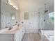 Bathroom featuring double sinks, a separate shower, and a tub under the window at 8417 Hirsch Dr, Charlotte, NC 28277