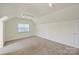 Bright bonus room with carpet, track lighting, and a neutral color palette at 8417 Hirsch Dr, Charlotte, NC 28277