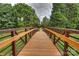 A wooden walking bridge is surrounded by lush greenery, offering a peaceful path through nature at 8417 Hirsch Dr, Charlotte, NC 28277