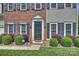 Close-up of the front door with brick facade and manicured landscaping enhancing curb appeal at 8417 Hirsch Dr, Charlotte, NC 28277